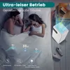 A couple sleeping in bed with a small white air purifier on a nightstand next to them. Náhled obrázku produktu