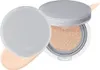 A cushion foundation compact with the lid open, showing the product inside and a swatch of foundation. Voir les images du produit