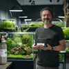 A man stands in a room filled with aquariums, holding a CO2 set. Anteprima dell’immagine prodotto