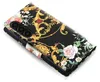 A close-up, angled view of a black smartphone case with a floral and ornate gold pattern. Produktbild-Vorschau