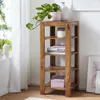 A wooden shelf unit with decorative items and books in a room with natural light. Podgląd zdjęcia produktu