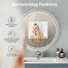 A round bathroom mirror with LED lighting, showing a woman's reflection and featuring icons and text describing its functions. Voir les images du produit