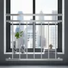 A silver balcony railing is installed in front of a window with a city view. Anteprima dell’immagine prodotto