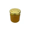 A small, clear glass jar filled with a golden liquid, likely honey, and sealed with a metallic gold twist-off lid. The jar is presented against a plain white background. Voir les images du produit