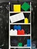 A white ladder shelf filled with various colored LEGO storage bricks against a black textured background. Produktbild-Vorschau