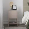 A bedside table with a lamp, e-reader, and phone. Produktbild-Vorschau