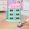 A child's hand is playing with a toy car in front of a dollhouse. Anteprima dell’immagine prodotto