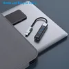 A USB hub is placed on top of a laptop, next to a smartphone and a grey carrying case. Produktbild-Vorschau