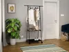 A hallway or entryway scene with a clothing rack, plant, and door. Náhľad obrázku produktu