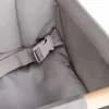 Close-up of a grey fabric seat with a grey buckle and strap, and a wooden element. Náhled obrázku produktu