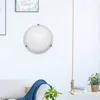 A round ceiling light is mounted on a white wall above a sofa with a blue throw blanket. Produktbild-Vorschau