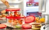 Food items in glass containers with red lids are arranged on a counter in front of an open refrigerator. Produktbild-Vorschau