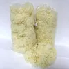 Two clear plastic bags filled with fluffy, cream-colored material, likely stuffing, are shown against a white background. A pile of the same material is in the foreground. Produktbild-Vorschau