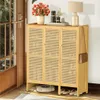 A shoe cabinet with woven doors is placed in an entryway next to a door, with a robot vacuum cleaner underneath and slippers on the floor. Podgląd zdjęcia produktu