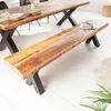 A wooden bench with black X-shaped legs is placed in front of a wooden dining table, also with black X-shaped legs. Produktbild-Vorschau