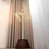 A decorative LED tree with a woven basket base is placed in a room with curtains. Produktbild-Vorschau