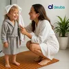 A mother is drying her child's hair with a towel in a bathroom setting. Produktbild-Vorschau