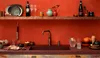A kitchen counter with a sink, faucet, and various items on the counter and a shelf above. Anteprima dell’immagine prodotto
