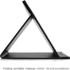 A black folding makeup mirror is shown in profile, propped open. Produktbild-Vorschau
