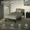 A bedroom scene featuring a black metal bed with green bedding and a decorative pillow. Náhled obrázku produktu