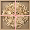 A straw star decoration is presented in a cardboard box, tied with a red and white checkered ribbon. Produktbild-Vorschau