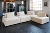 A modular sofa in a modern living room with dark wooden floors and large windows. Produktbild-Vorschau
