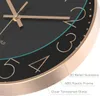 A close-up view of a black wall clock with gold numbers and hands, showing details of its construction and materials. Produktbild-Vorschau