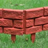 A close-up view of red brick-patterned garden edging installed in grass. Produktbild-Vorschau