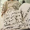 A person is wrapped in a blanket with text and stamps on it. Produktbild-Vorschau