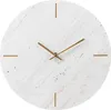 A close-up of a round wall clock with a marble-like pattern and gold hands. Voir les images du produit