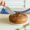 A hand is cutting a marble cake with a knife, with a blue cake ring in the background. Produktbild-Vorschau