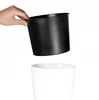A hand is holding a black pot over a white pot. Anteprima dell’immagine prodotto
