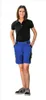 A woman is posing in a studio setting, wearing a black polo shirt and blue shorts. Produktbild-Vorschau