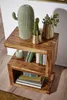 A wooden side table with decorative items and books. Produktbild-Vorschau
