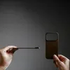 Hands holding a brown phone case against a gray background. Anteprima dell’immagine prodotto