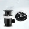 A black sink drain assembly and stopper are shown against a background of rippling water. Produktbild-Vorschau