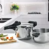 A kitchen counter with two stainless steel pots, one a pressure cooker, and some vegetables. Náhled obrázku produktu