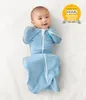 A baby is lying on its back, swaddled in a blue swaddle bag. There is a yellow award badge in the top right corner. Anteprima dell’immagine prodotto
