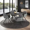A dining set with four chairs around a round table, placed on a rug in a modern room with a view of an outdoor balcony. Produktbild-Vorschau