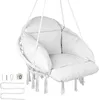 A white macrame hanging chair with cushions and tassels, suspended by ropes. Mounting hardware is visible to the left. Podgląd zdjęcia produktu
