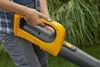 A person holding a yellow and black leaf blower in an outdoor setting with green foliage in the background. Produktbild-Vorschau