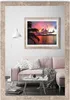 A living room scene featuring a pink sofa, a coffee table, a floor lamp, and a framed picture of a sunset over the ocean. Produktbild-Vorschau