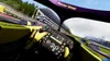 First-person view from inside a racing car cockpit, showing the steering wheel and dashboard. Produktbild-Vorschau