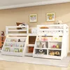 A white loft bed with integrated bookshelves and storage, decorated with children's artwork and toys. Voir les images du produit