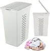 A white laundry basket with a lid and a pile of laundry. Voir les images du produit