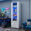 A white display cabinet with LED lighting, placed in a room with a gaming setup. Produktbild-Vorschau