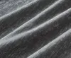A close-up view of dark gray chenille fabric with folds and texture. Produktbild-Vorschau