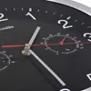 A close-up view of a black wall clock with white numbers and hands, featuring a hygrometer and thermometer. Podgląd zdjęcia produktu