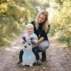 A mother and child playing with a toy dog in a park. Produktbild-Vorschau