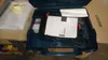 A Bosch hammer drill is shown inside its blue plastic case, along with some documentation and packaging materials. Náhled obrázku produktu